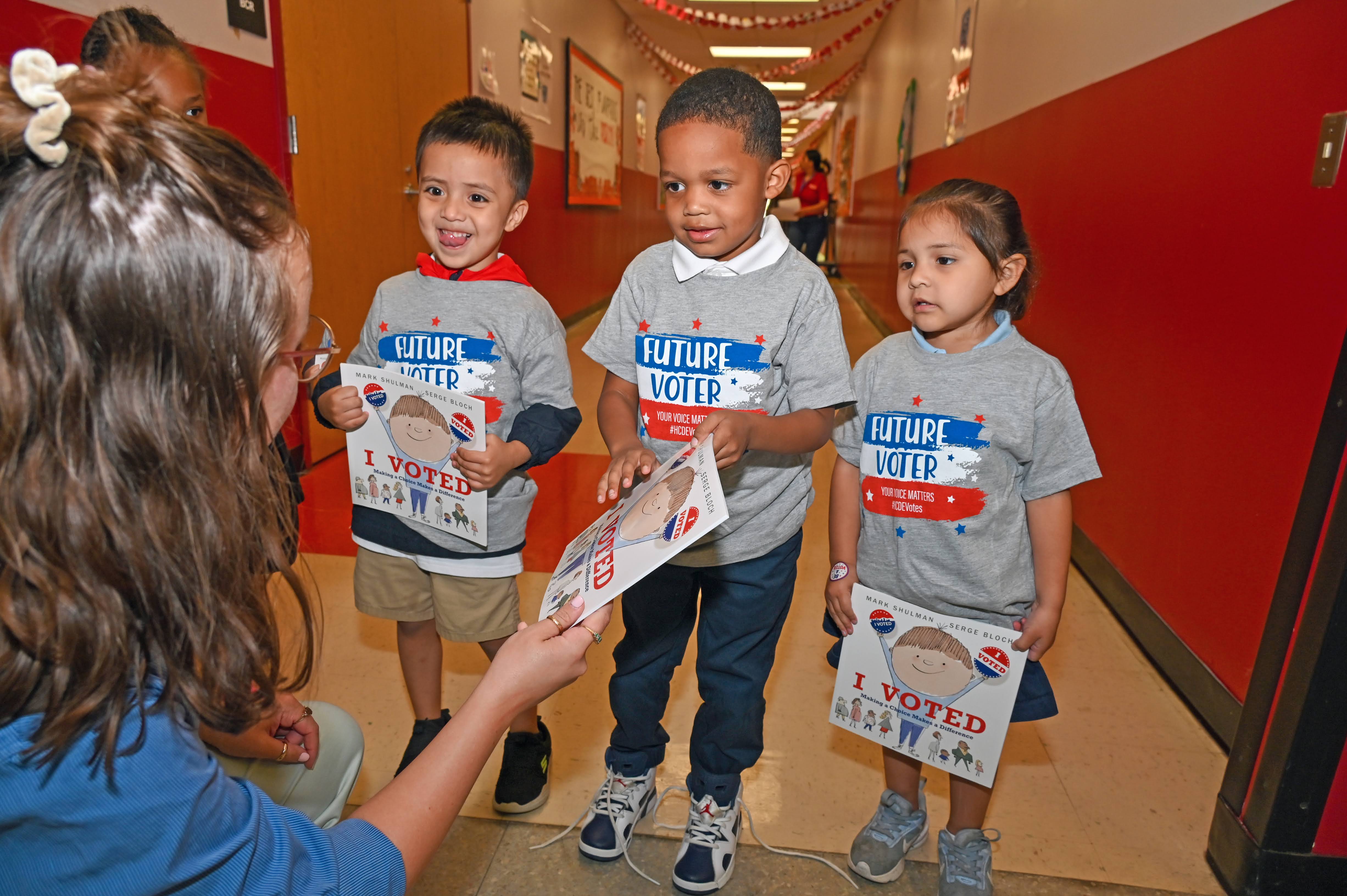 Image of students holding books about voting